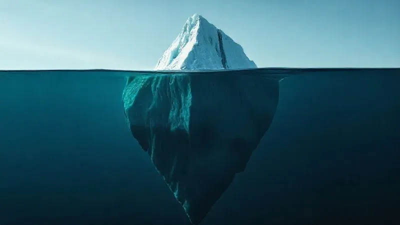 A photorealistic, professional photography, 8K, cinematic lighting, sharp focus, depth of field, shot on a high-end DSLR, depicting a large iceberg with only a small portion visible above calm water, while a much larger, shadowy mass is submerged beneath. The water is clear enough to hint at the hidden depths, symbolizing unseen customer dissatisfaction. The overall mood is thoughtful and revealing.