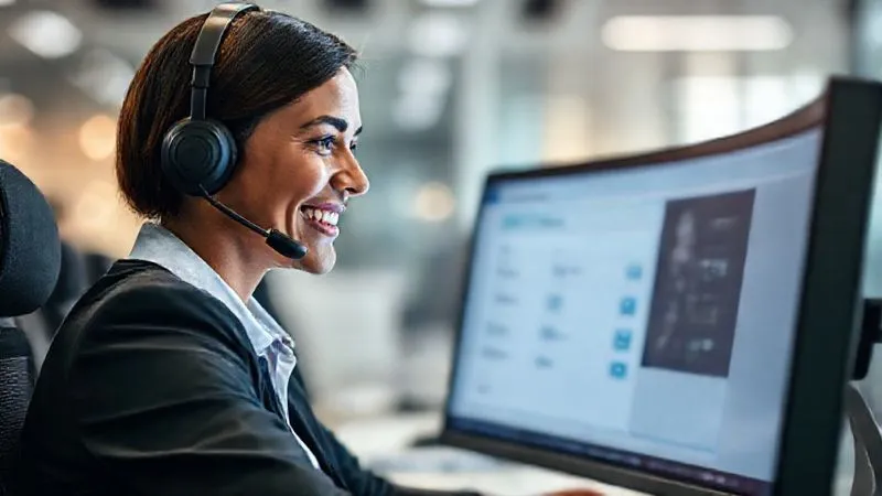 A photorealistic image of a professional customer service representative, wearing a headset, smiling empathetically while looking at a computer screen displaying a clear, user-friendly refund interface. The background is a modern, clean call center, cinematic lighting, sharp focus on the representative, depth of field blurring the background, 8K, professional photography.