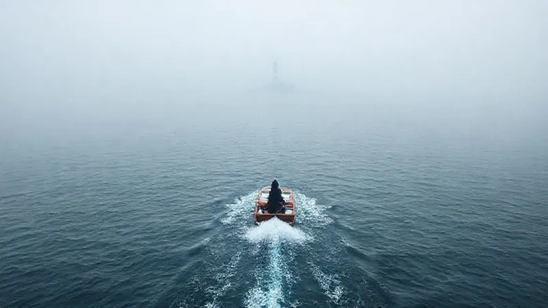 A photorealistic image of a single, determined small boat navigating through a vast, slightly foggy sea towards a distant, clearly visible lighthouse. The boat leaves a persistent wake, symbolizing consistent effort and follow-up. Cinematic lighting, 8K, sharp focus, depth of field.